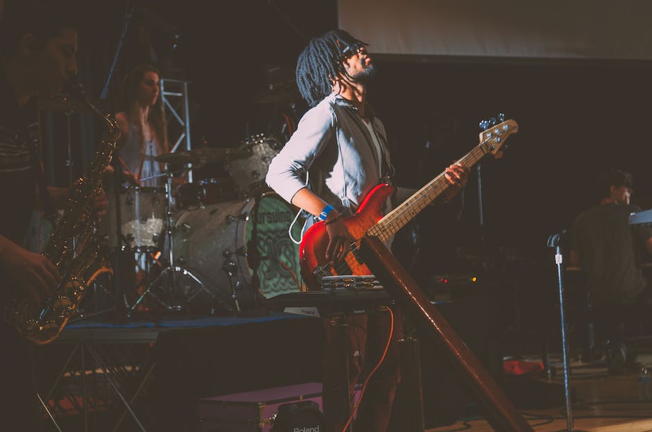 Image of a person playing a guitar on stage at a concert