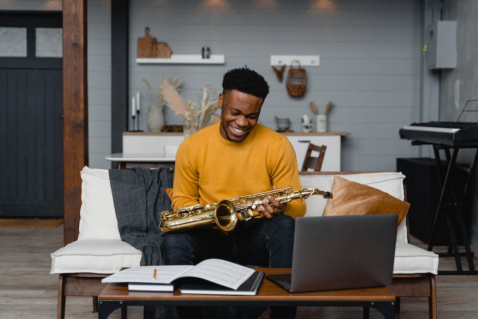 Image depicting a songwriter working on a song, surrounded by musical instruments and sheet music.